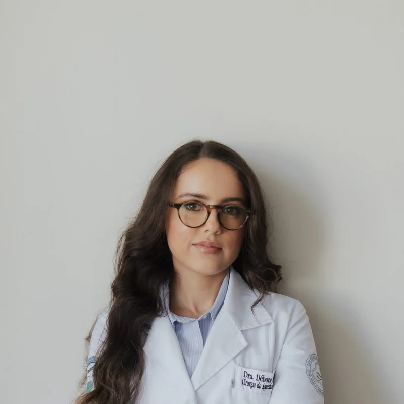 Dra. Débora Sampaio com jaleco cirúrgico