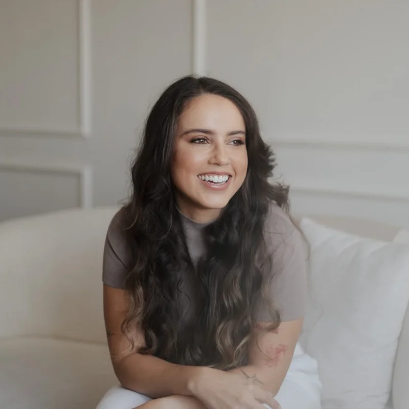 Dra. Débora Sampaio sorrindo no consultório
